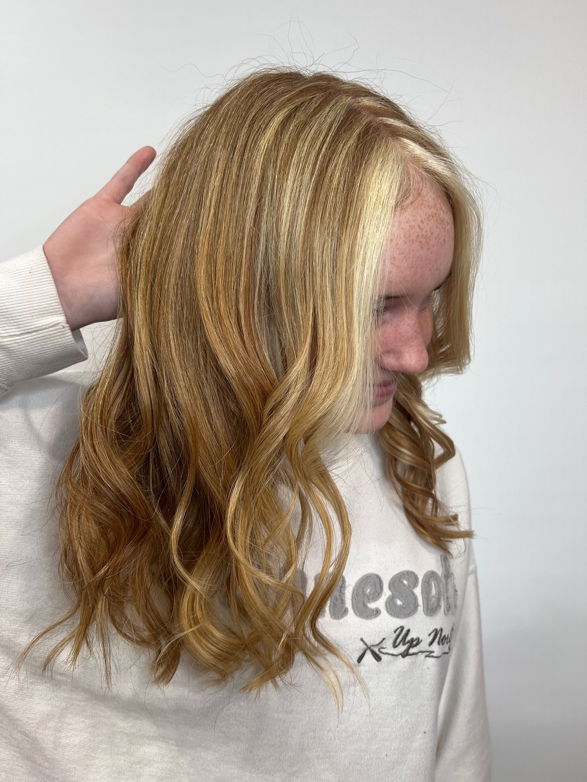 A woman with long blonde hair is wearing a sweater that says e80.