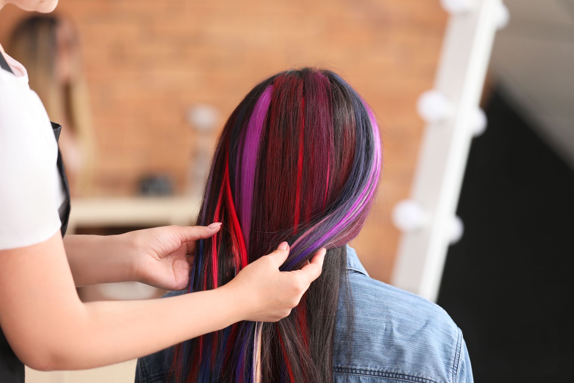 A woman is getting her hair dyed in a salon.