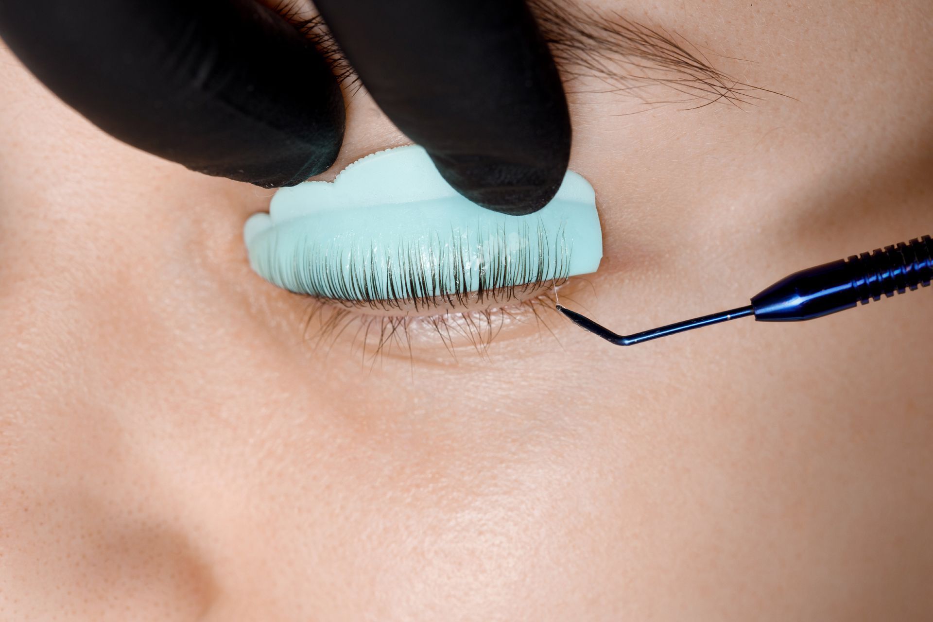 A close up of a woman 's eye getting a lash lift.