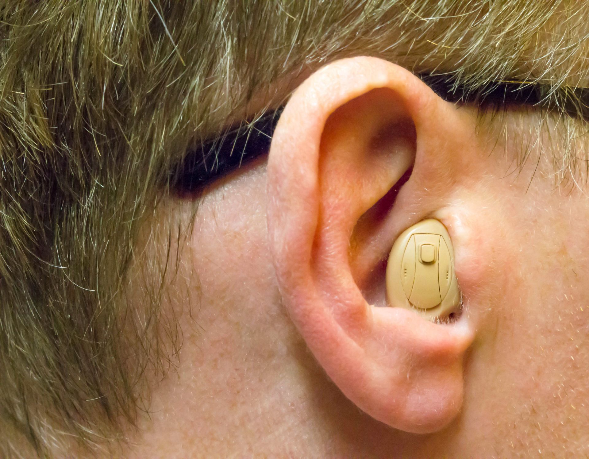 A close up of a person 's ear with a hearing aid in it