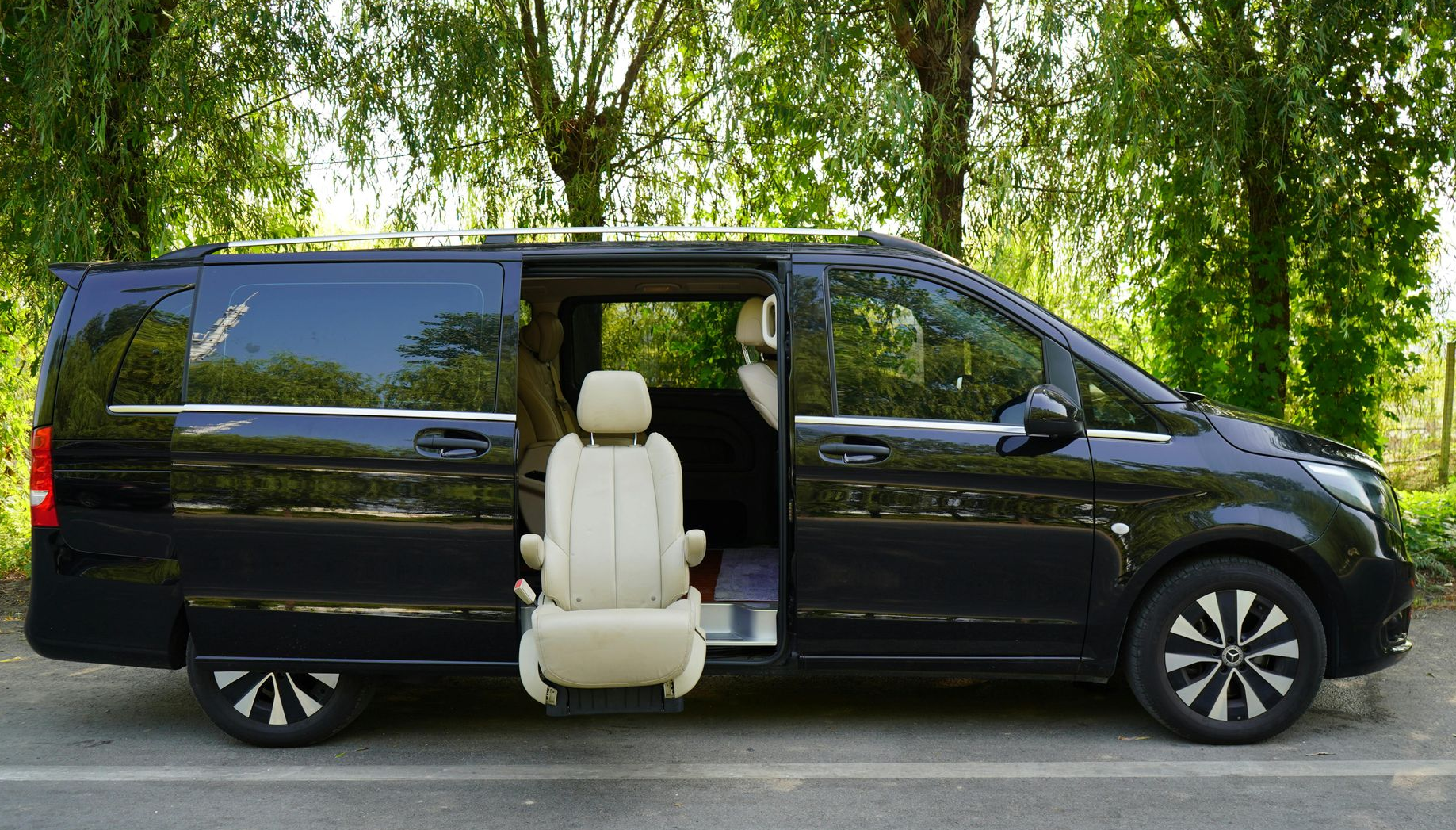Hands exchanging documents across a wooden table, possibly during a business meeting.