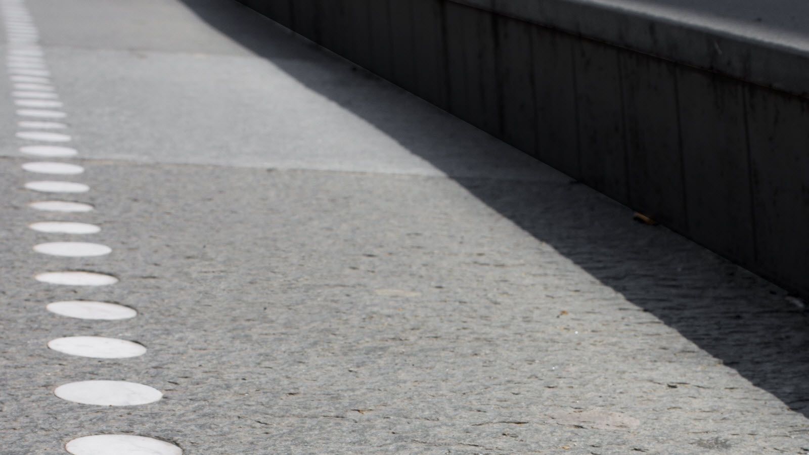 Een close-up van een weg met daarop geschilderde witte cirkels.