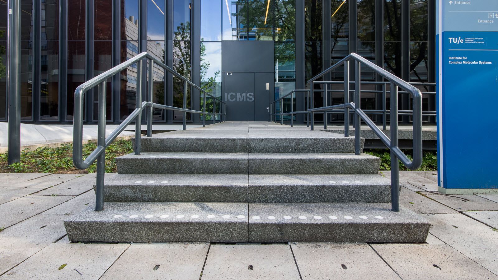 Een trap die naar een gebouw leidt met een leuning.