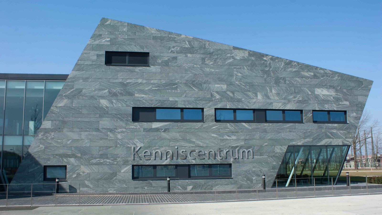 Een groot gebouw met veel ramen en een blauwe lucht op de achtergrond.