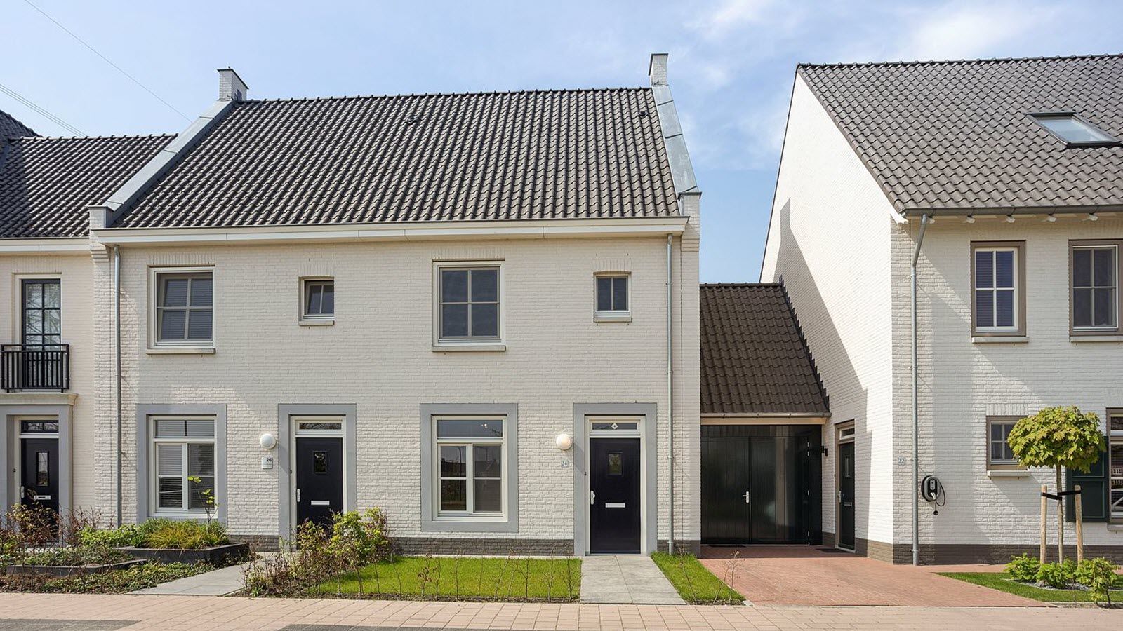 Een rij witte huizen met zwarte deuren en ramen