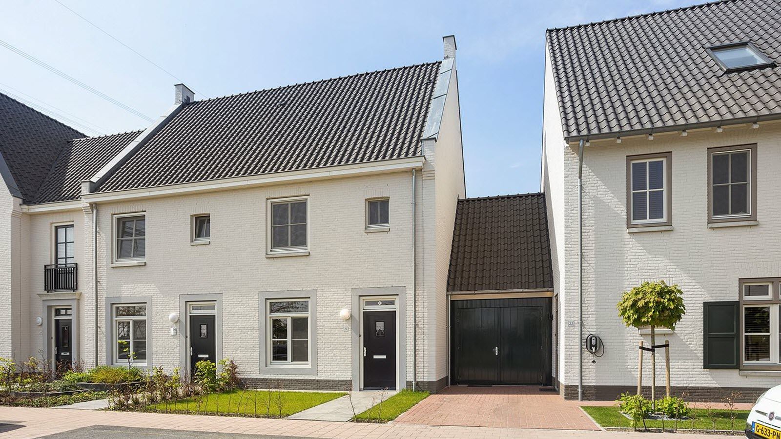 Een rij witte huizen met een zwart dak