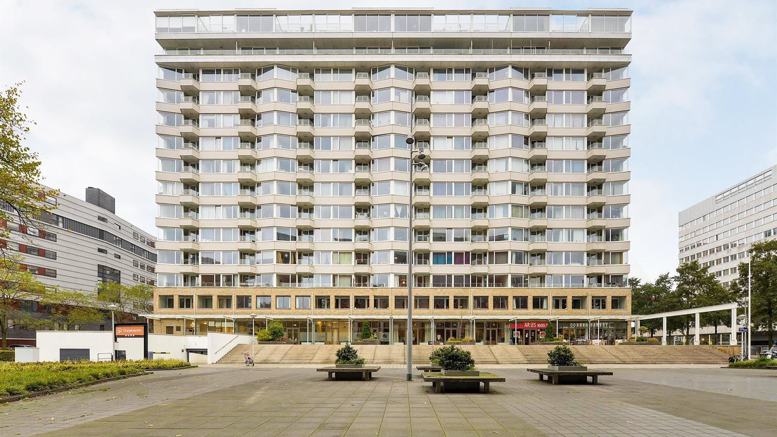 Een groot gebouw met veel ramen staat midden in de stad.