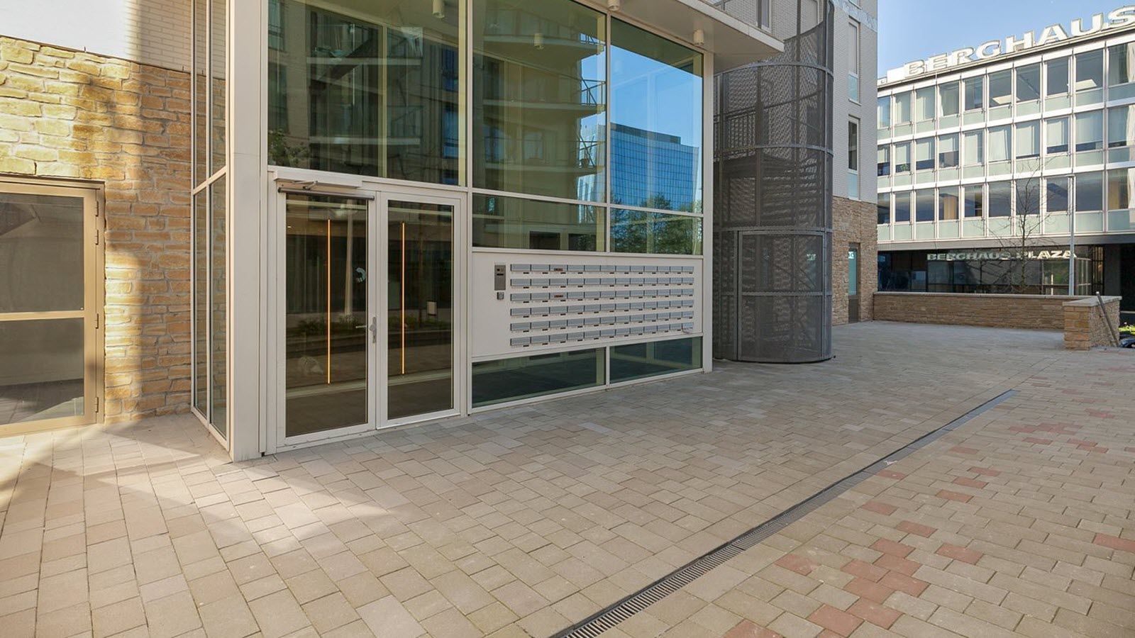 Een groot gebouw met veel ramen en een brievenbus ervoor.