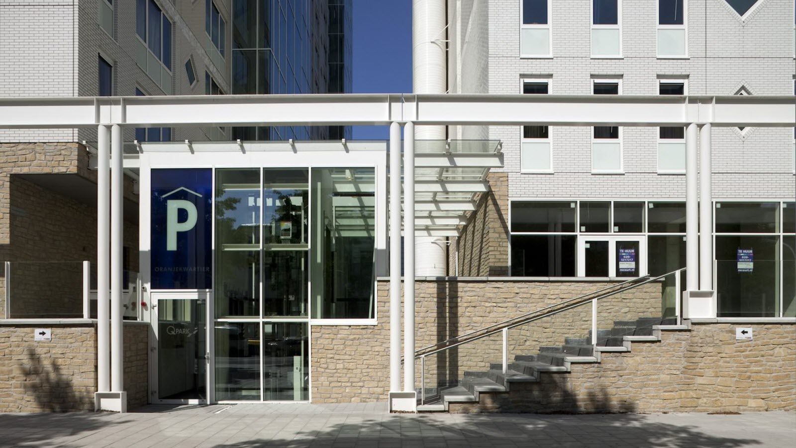 Een groot gebouw met een parkeerbord ervoor