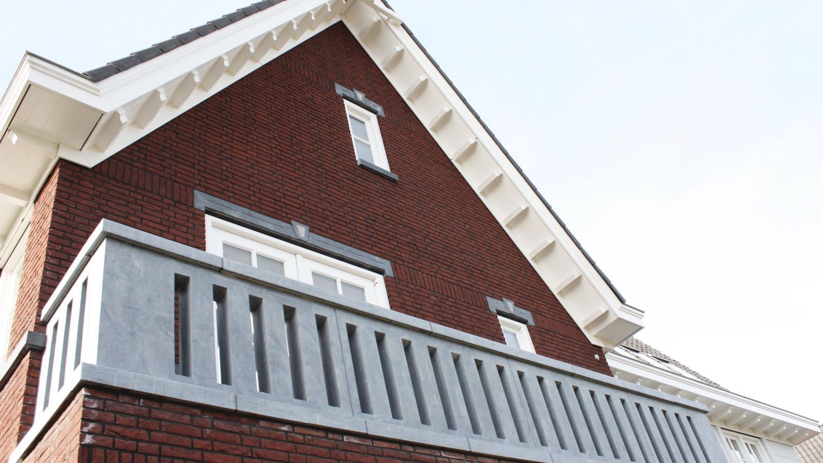 Een bakstenen huis met een balkon aan de zijkant