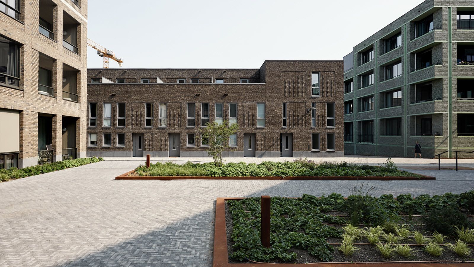 Een groot bakstenen gebouw met een tuin ervoor.