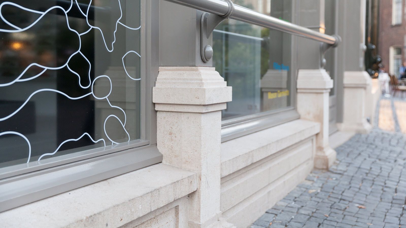 Een gebouw met een raam en een leuning op de stoep.