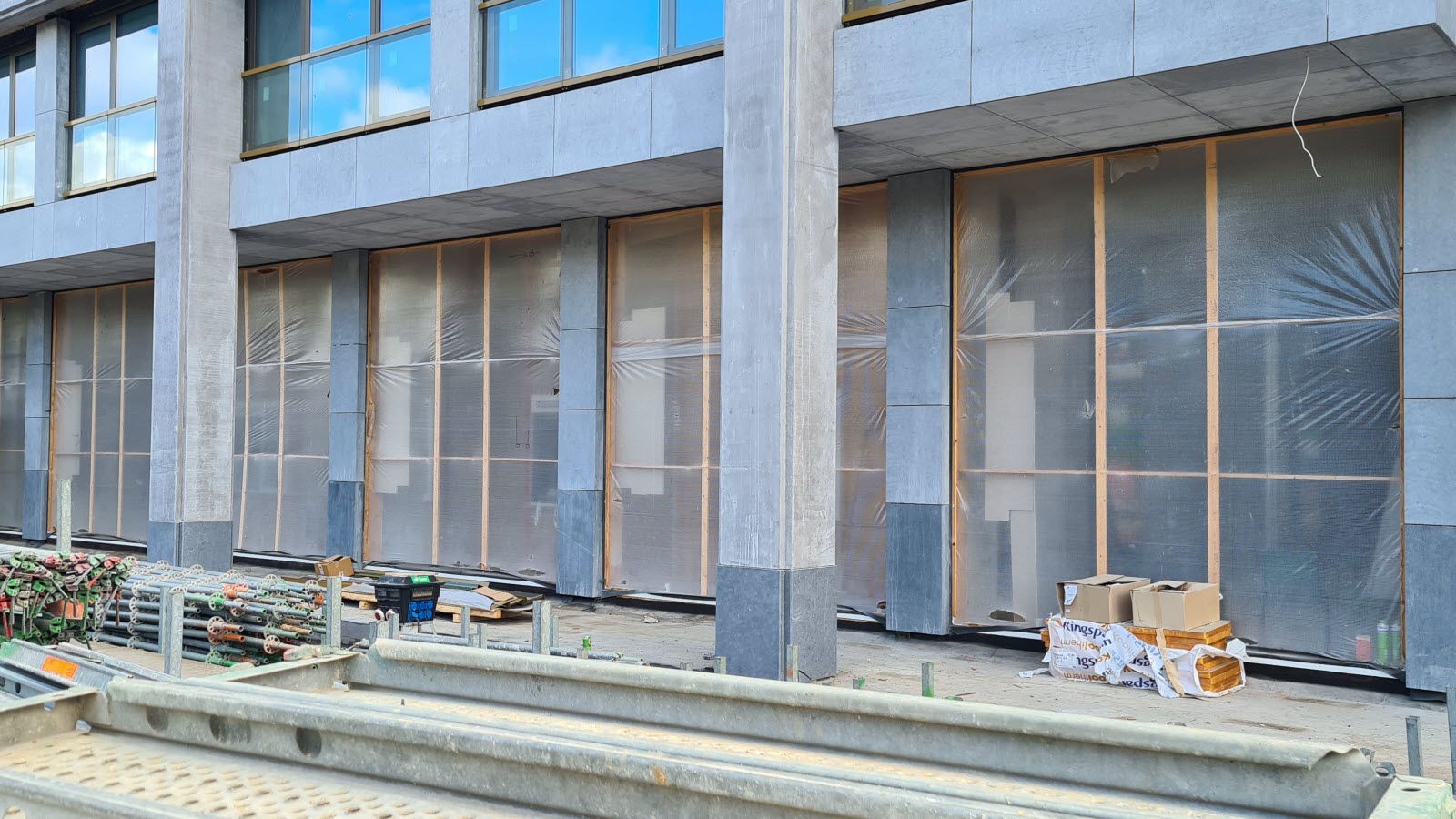 Een gebouw in aanbouw met veel ramen en trappen.