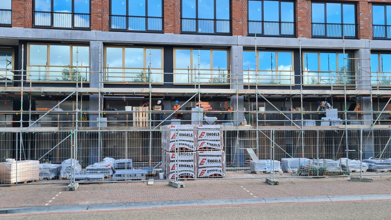 Er wordt een groot gebouw gebouwd met steigers eromheen.