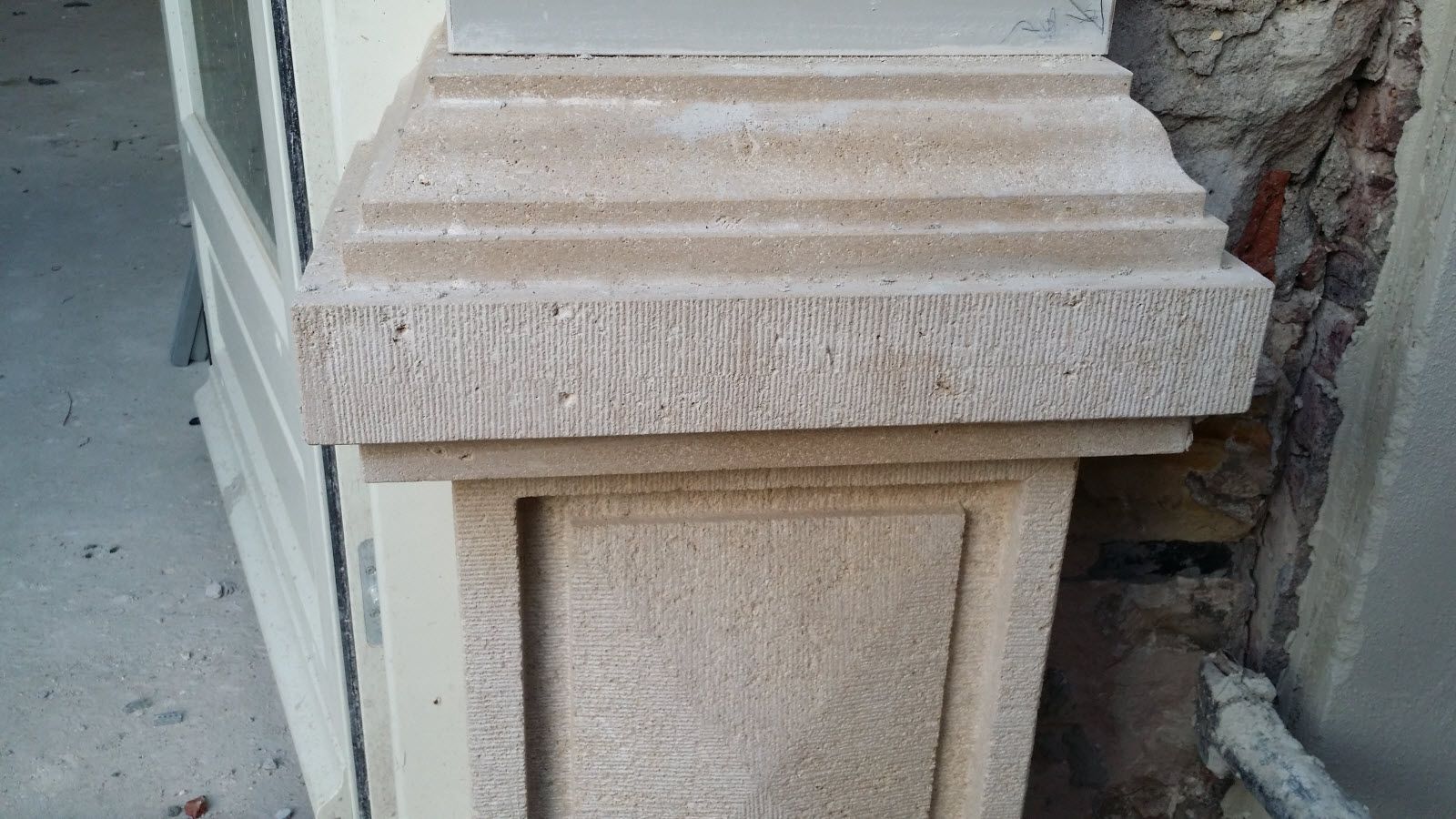 Een close-up van een stenen pilaar naast een deur.