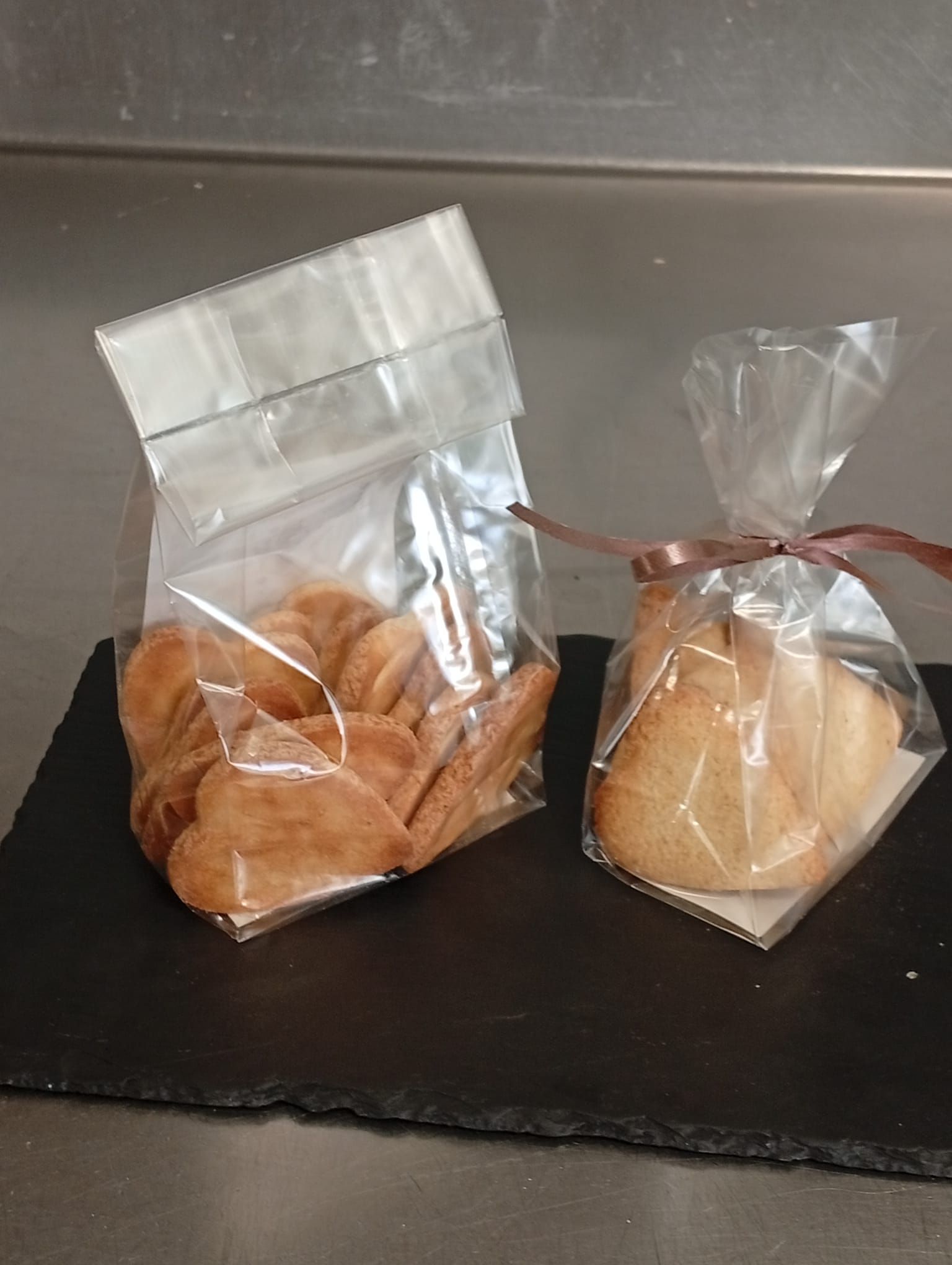 Due sacchetti di biscotti, uno più grande e uno più piccolo con un nastro marrone