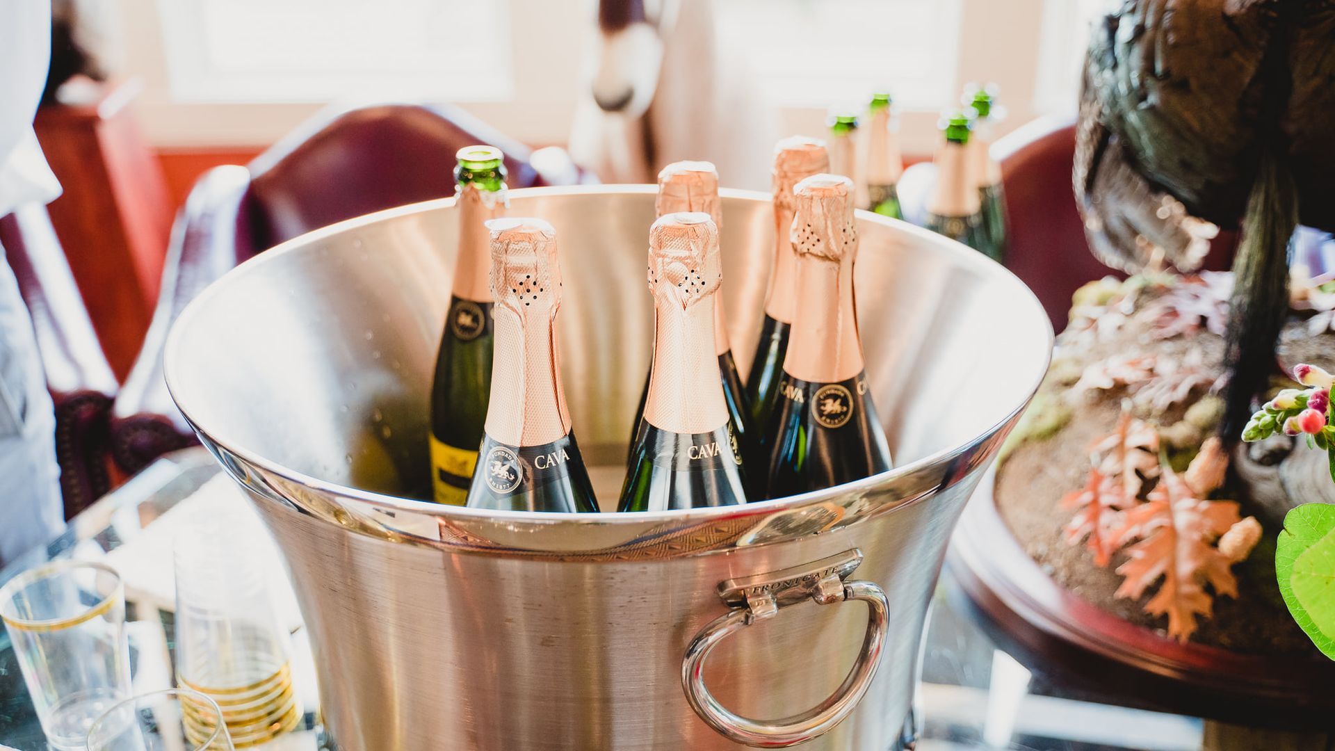 A bucket filled with bottles of champagne on a table.