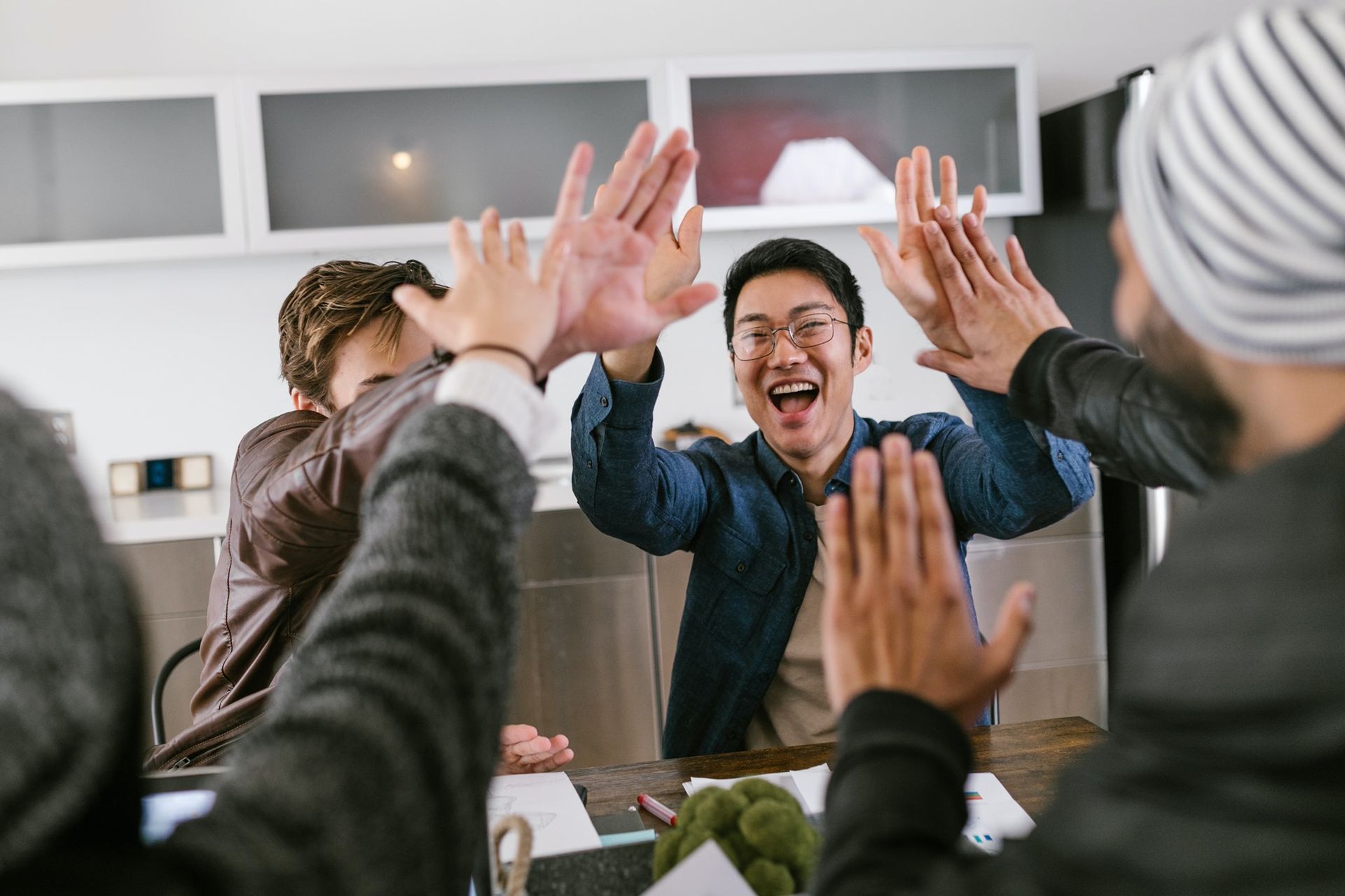 A group of men are giving each other a high five.