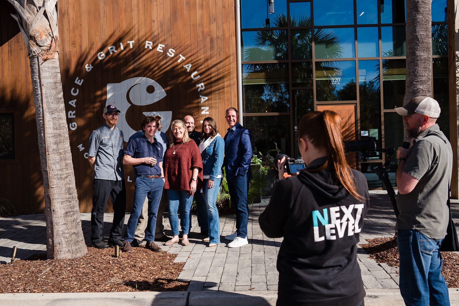 A group of people are posing for a picture in front of a restaurant.