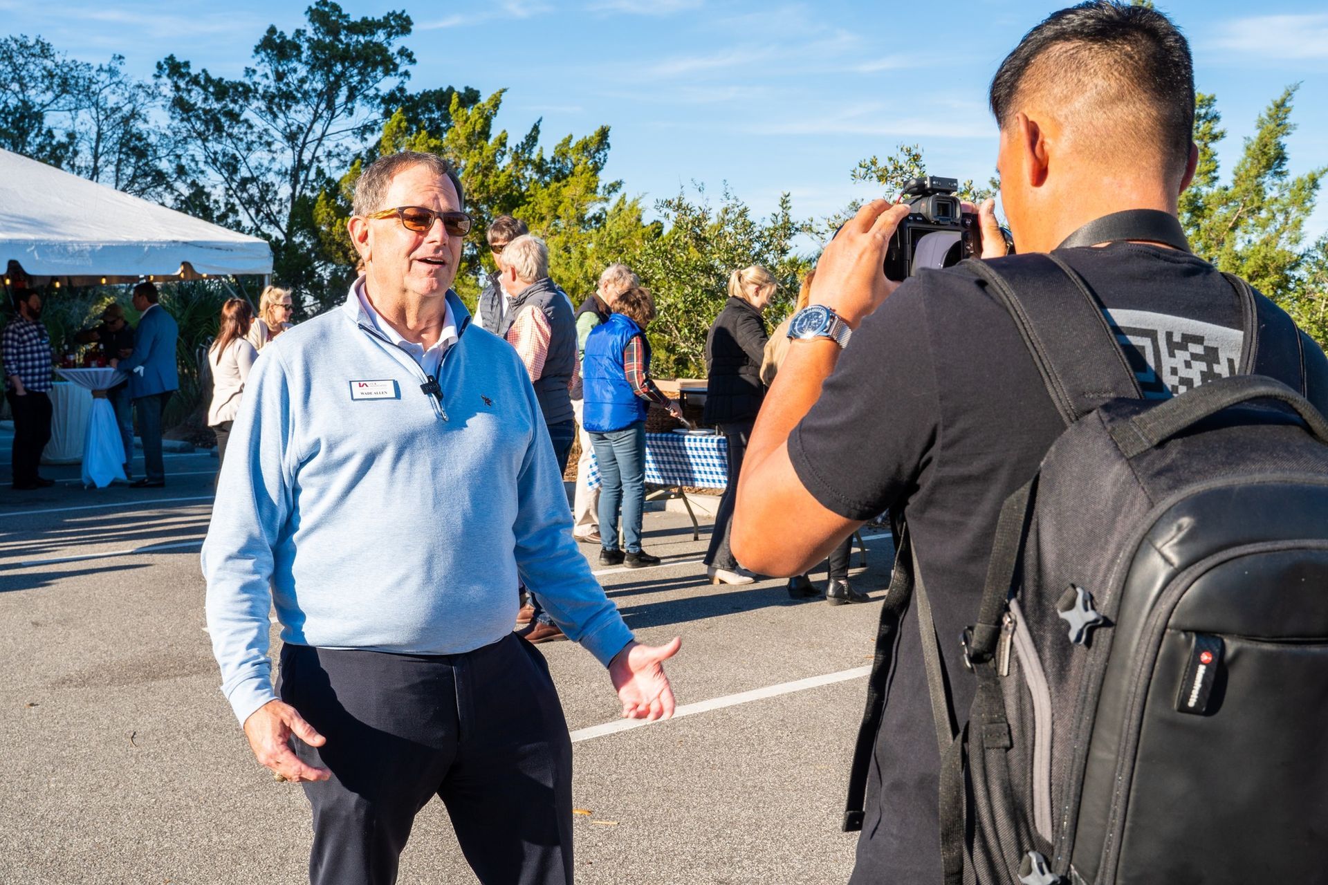 A man is standing in front of a camera while another man takes a picture of him.