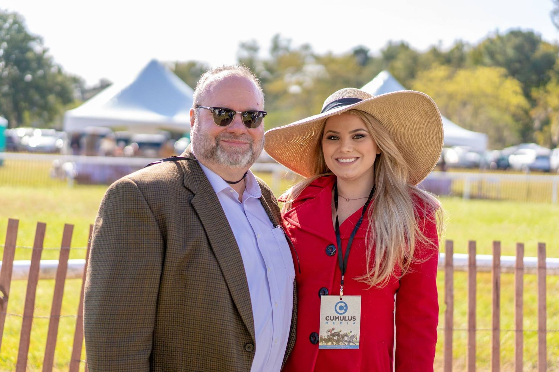 A man and a woman are standing next to each other in a field.