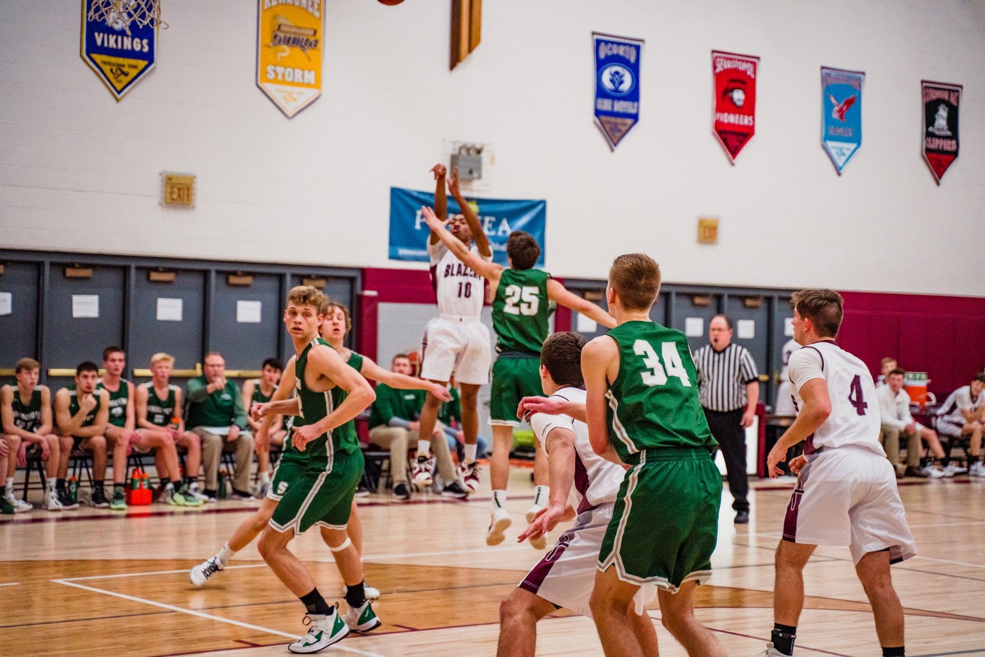 A group of young men are playing basketball in a gym.