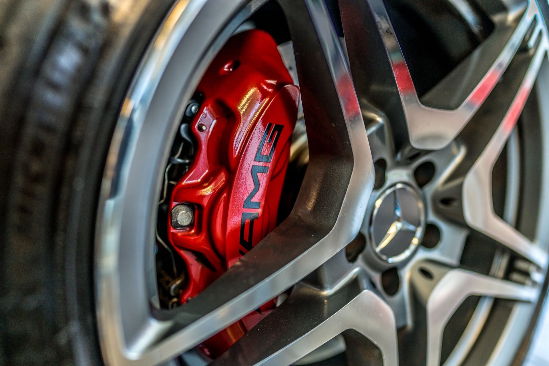 A close up of a mercedes amg wheel with a red brake caliper.