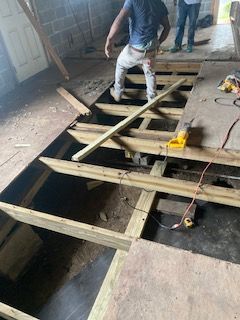 A man is standing on a wooden floor in a room.