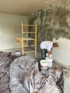 A man is painting a wall in a room.