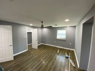 An empty room with a ceiling fan and a window.