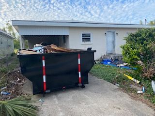 A dumpster is sitting in front of a house.