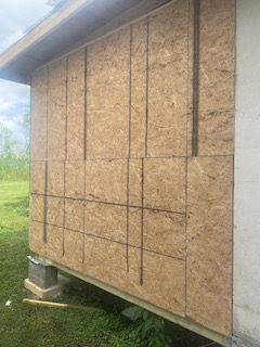 A house with a lot of plywood on the side of it.