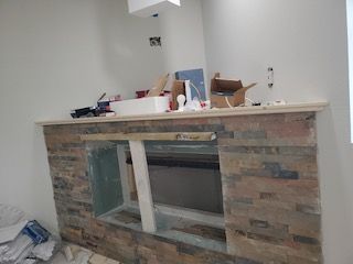 A brick fireplace is being built in a room.