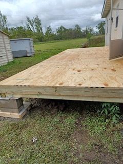 A wooden deck is being built in front of a house.