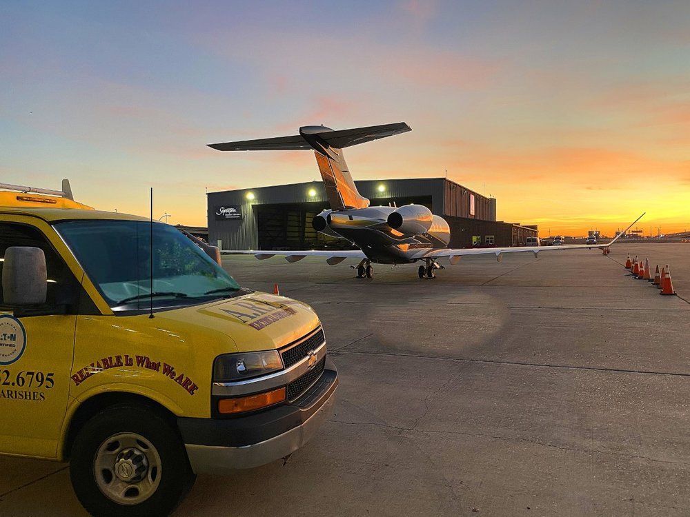 A yellow van is parked in front of an airplane