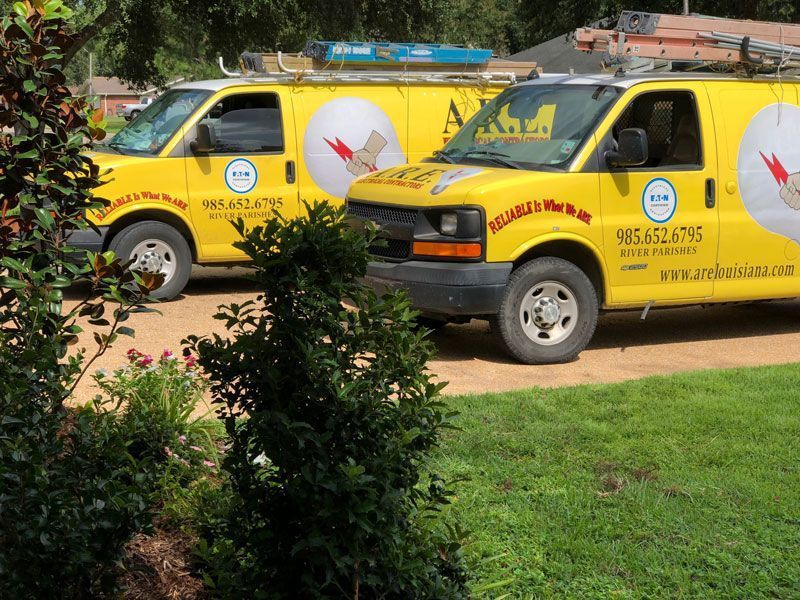 Two yellow vans are parked next to each other in a driveway