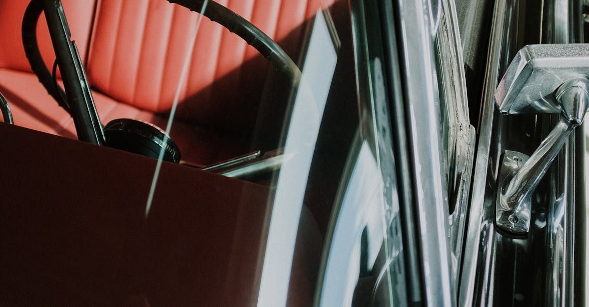 A vacuum cleaner is sitting on top of a pile of papers next to a red chair.