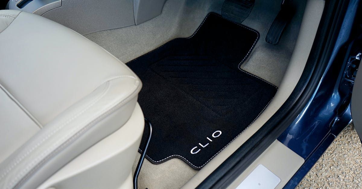A car with a black floor mat that says clio on it