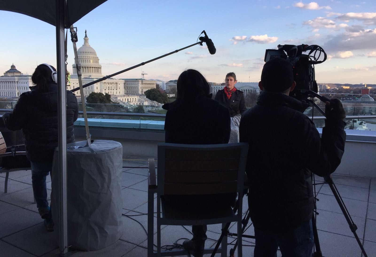 Filming outdoors in front of the Capitol Building. Crew uses cameras and microphones. One person is speaking.