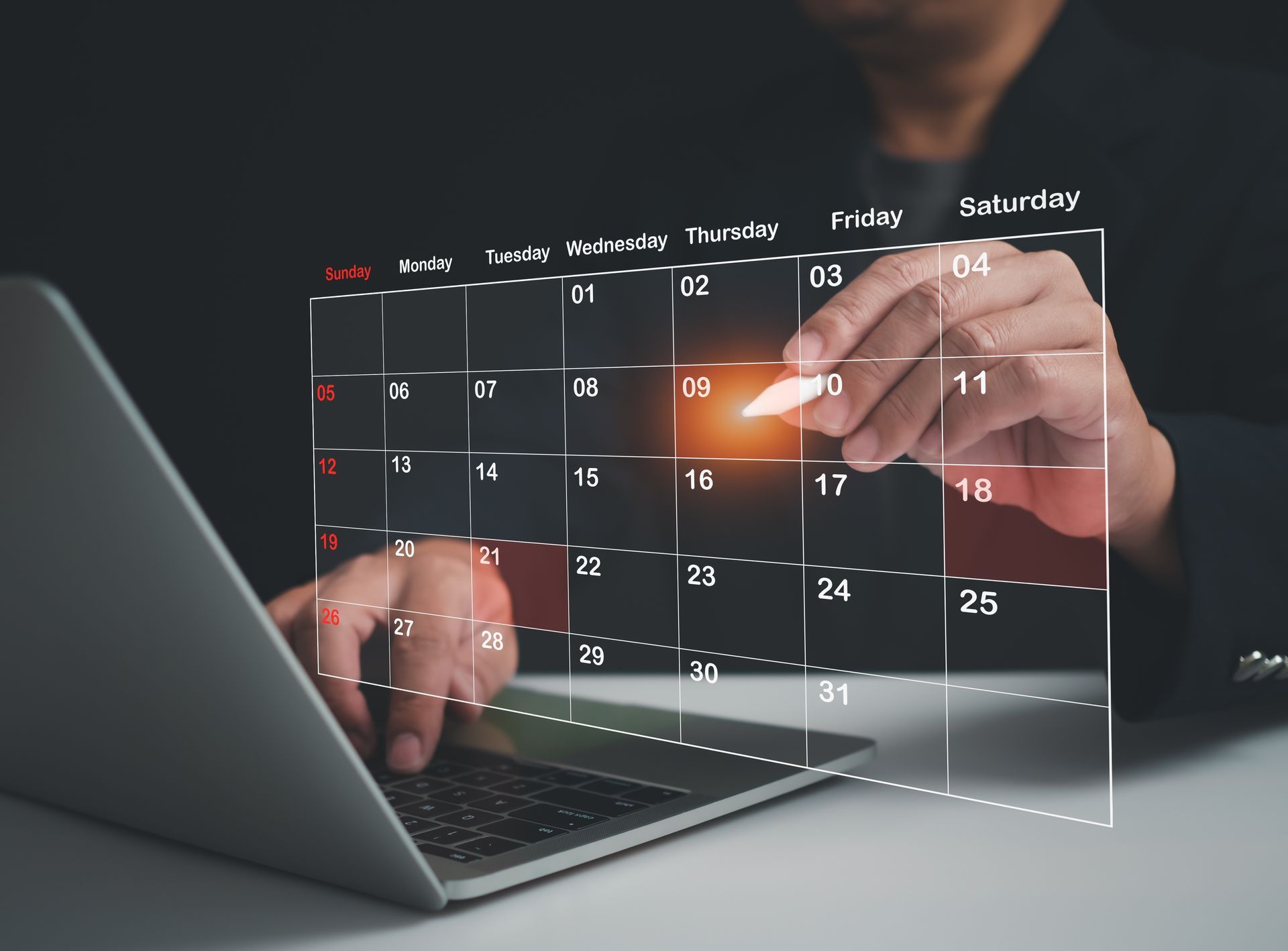 Person using a laptop, interacting with a digital calendar highlighting a specific date.