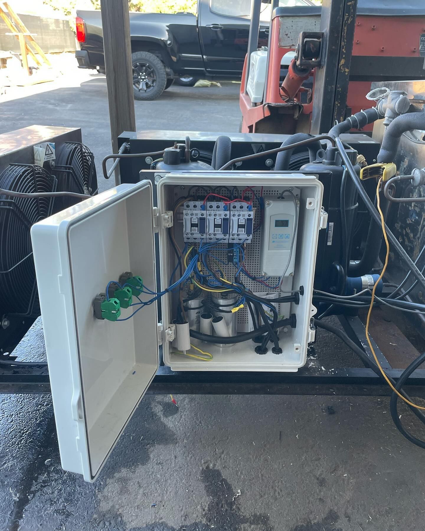 Open electrical panel with wires, breakers, and meter on a machine.