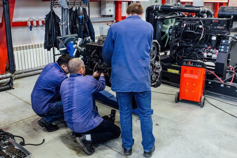 A group of men are working on a car engine in a garage.