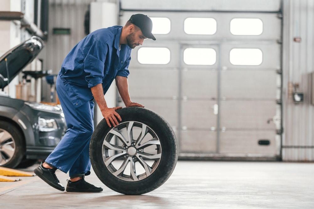 A mechanic is changing a tire in a garage.