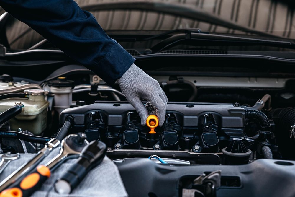 A mechanic is checking the oil level of a car engine.