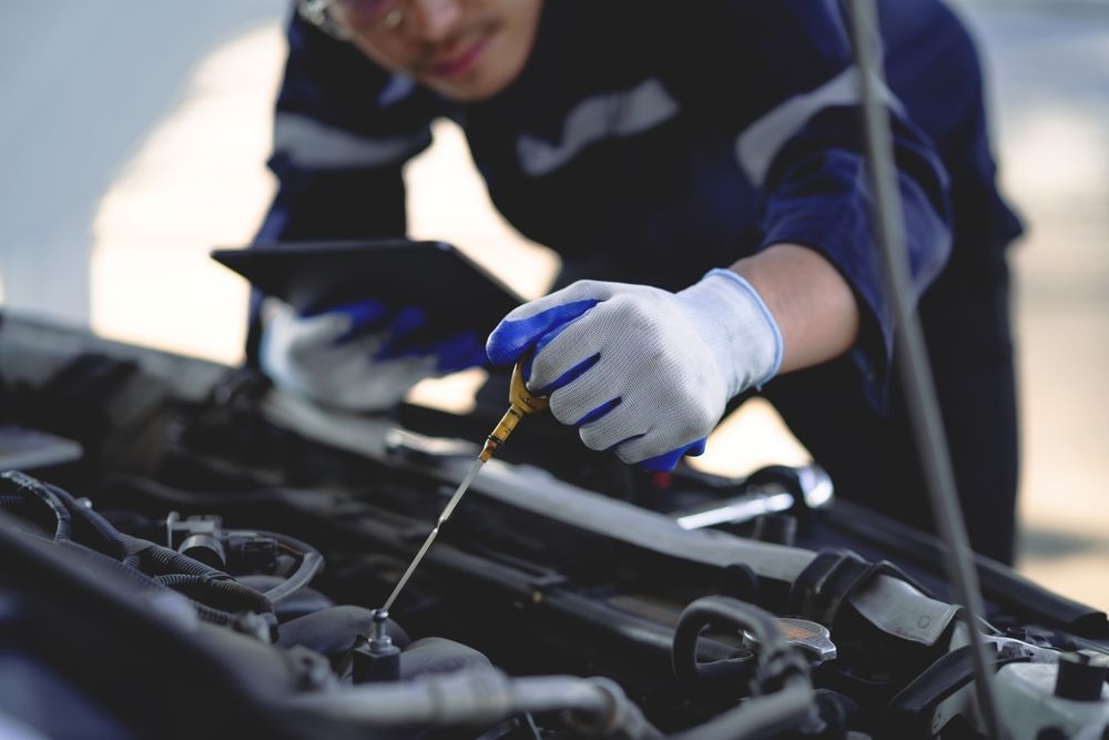 A mechanic is checking the oil level of a car.