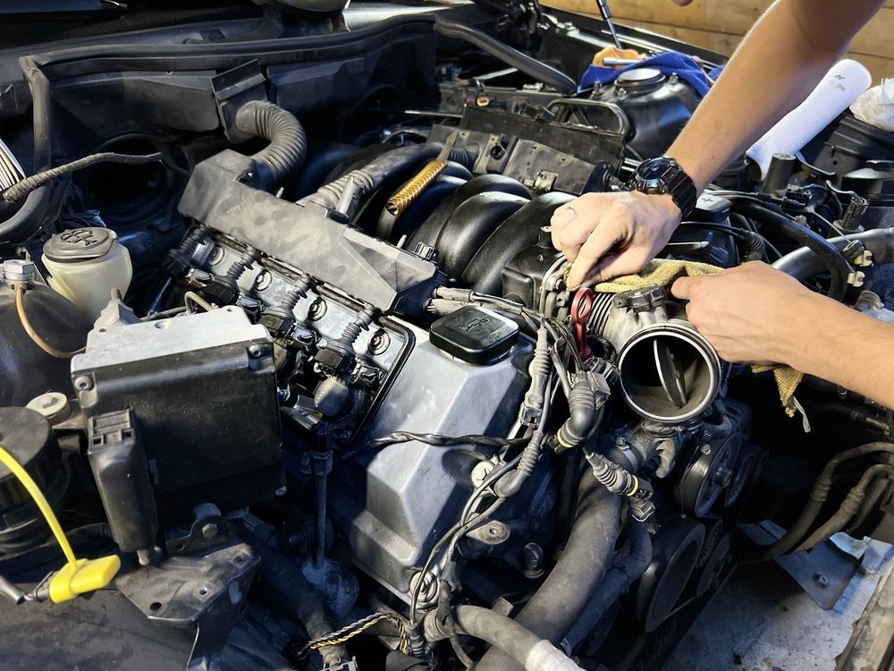 A person is working on the engine of a car.