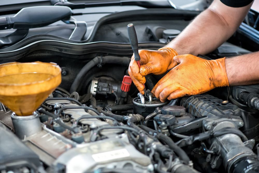 A man is working on the engine of a car.