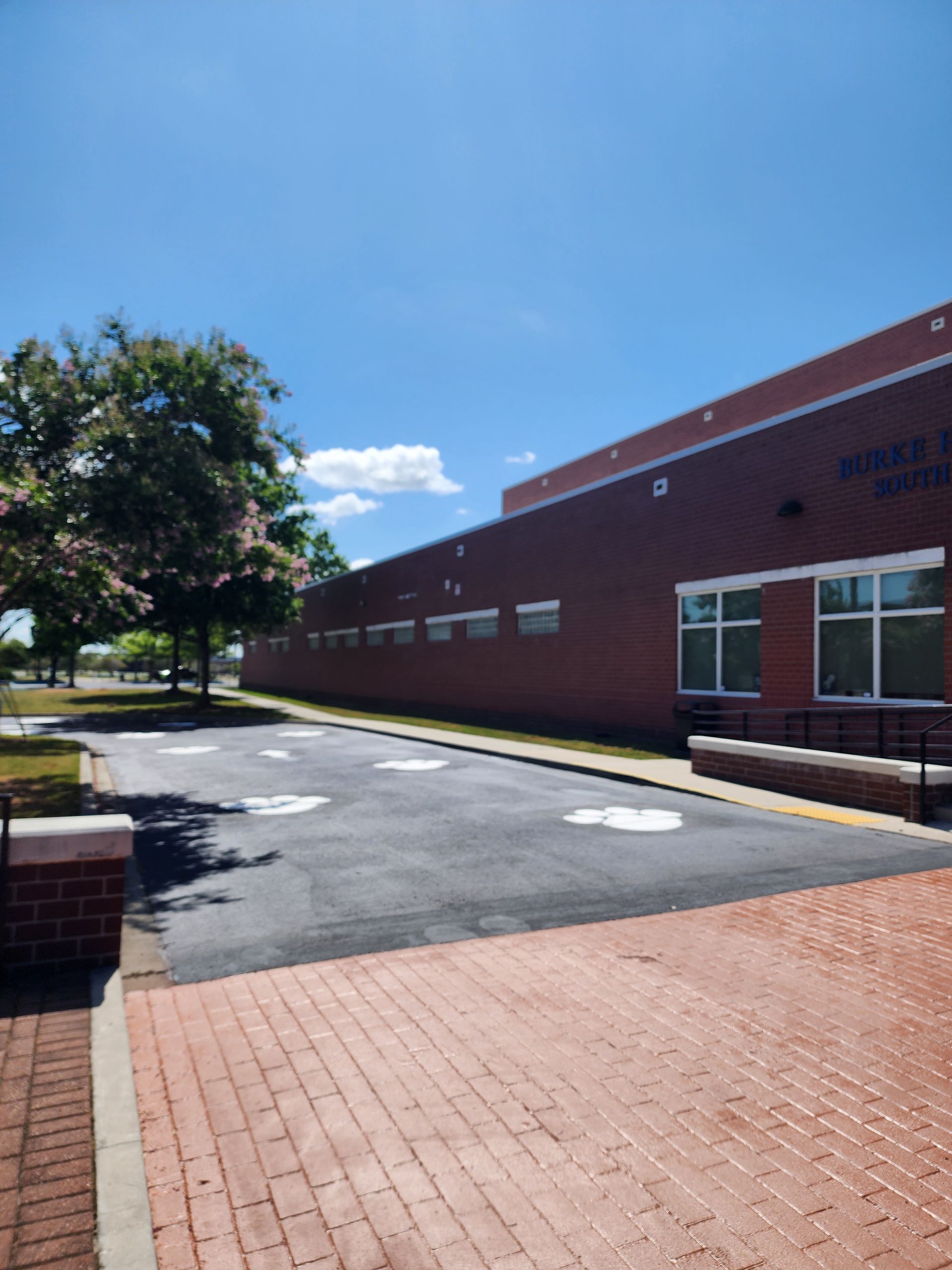 Cracked and worn school parking lot before asphalt paving in Charleston, SC by ABC Paving.