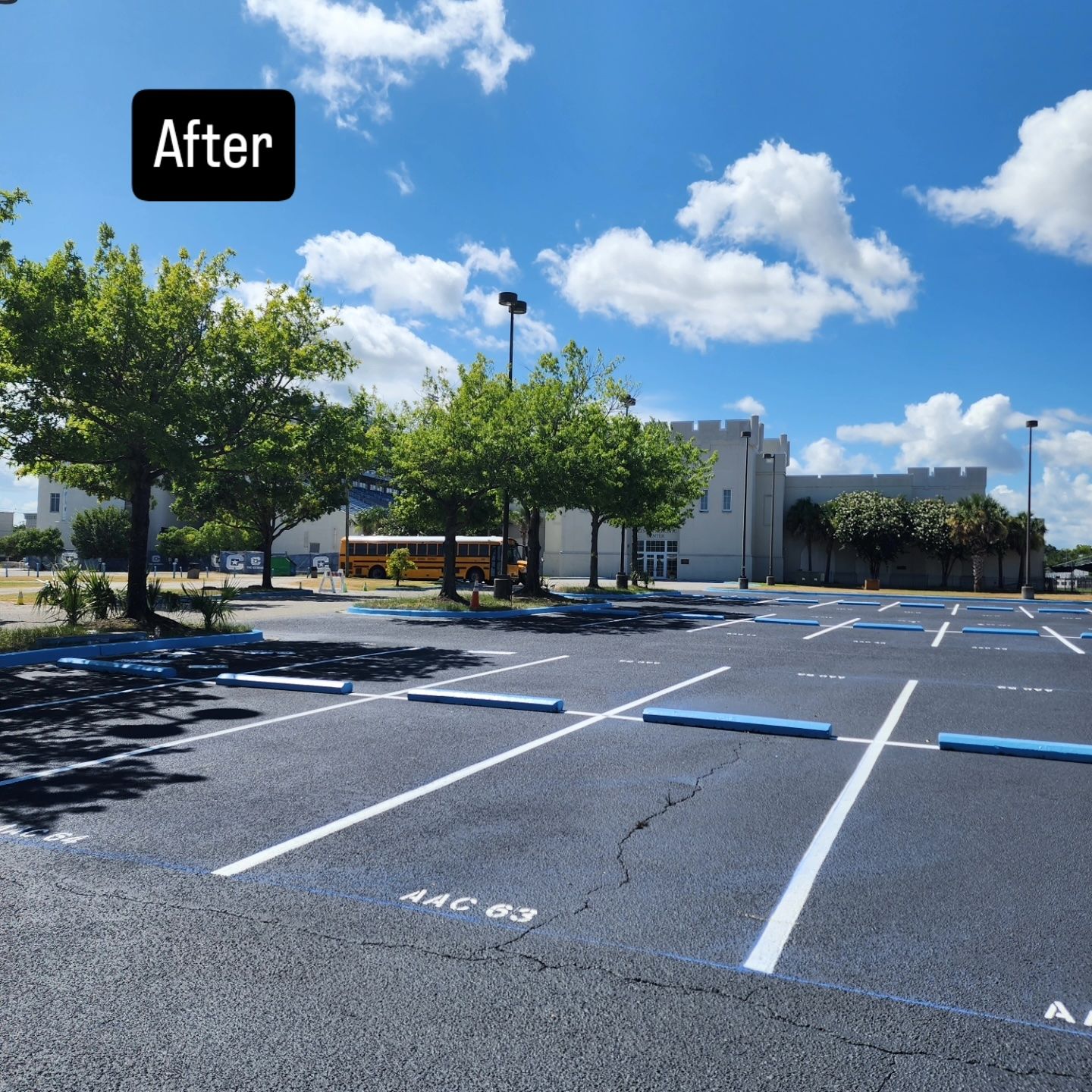 A parking lot with yellow lines and a building in the background