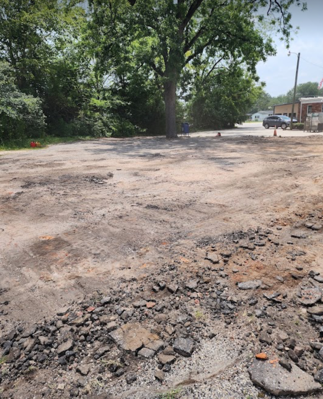 A dirt road with a tree in the background